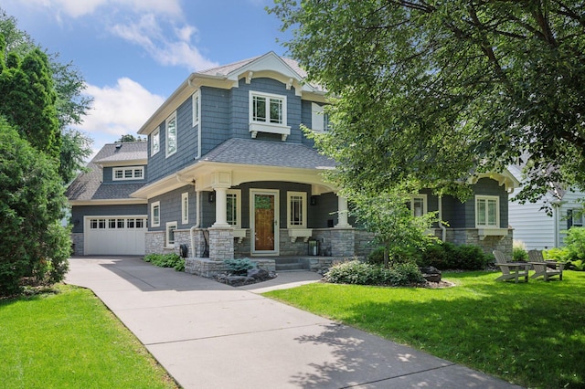 view of front of property with a garage, stone siding, driveway, and a front yard