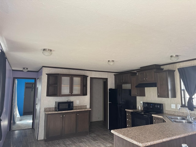 kitchen featuring dark wood-type flooring, a peninsula, dark brown cabinets, black appliances, and a sink