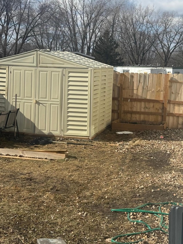 view of shed featuring fence