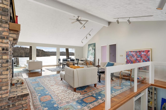 living area featuring a textured ceiling, high vaulted ceiling, a water view, a ceiling fan, and beamed ceiling