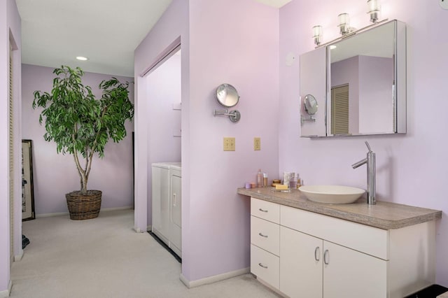 bathroom featuring recessed lighting, vanity, baseboards, and separate washer and dryer