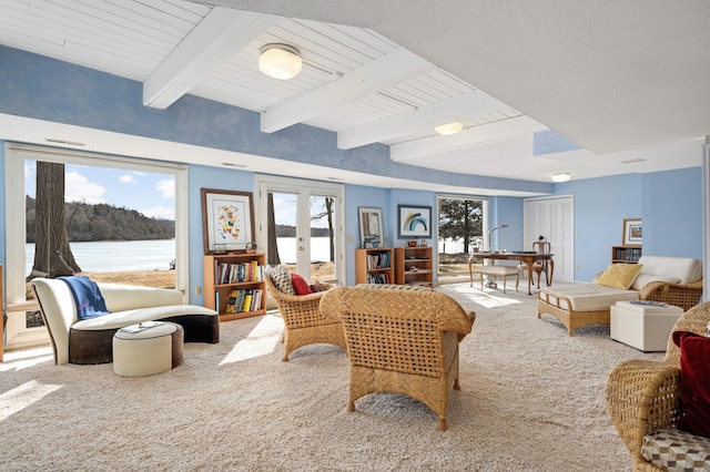 living area with carpet, french doors, and beam ceiling