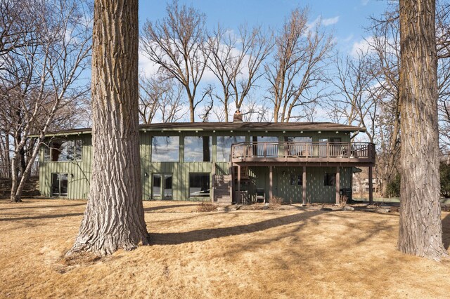 back of house with stairway, a chimney, and a wooden deck