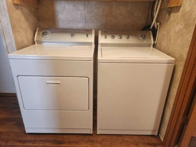 clothes washing area featuring laundry area, independent washer and dryer, and dark wood-style flooring