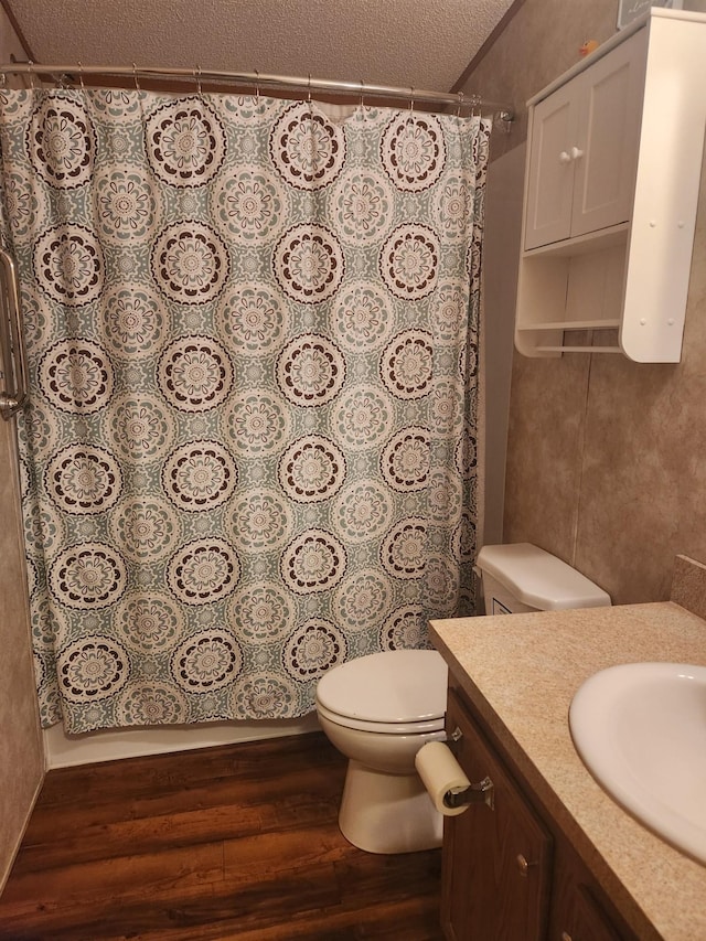 full bath with toilet, vanity, a textured ceiling, wood finished floors, and a shower with curtain