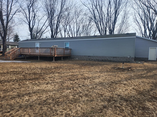 rear view of property featuring crawl space and a deck