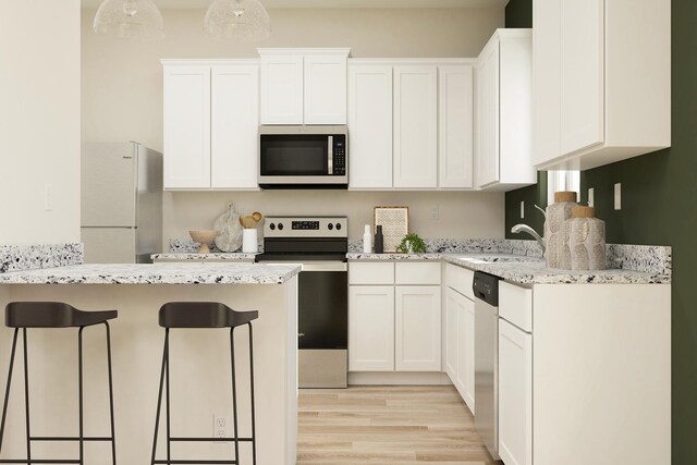424 Wildflower Ct, Waverly, MN 55390 - kitchen featuring white cabinetry, a kitchen breakfast bar, a sink, and stainless steel appliances