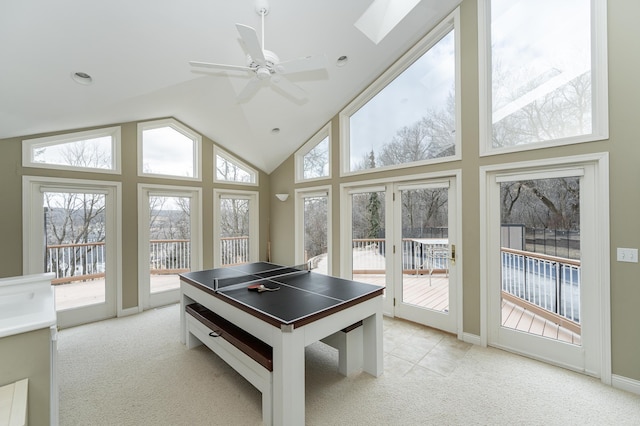 rec room featuring light carpet, a skylight, a ceiling fan, high vaulted ceiling, and recessed lighting