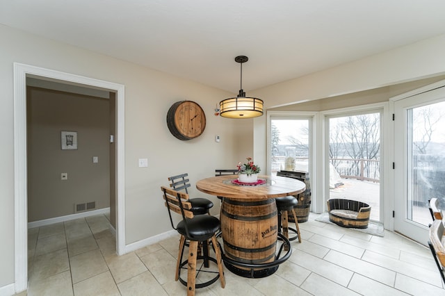 dining area featuring baseboards, visible vents, and light tile patterned flooring