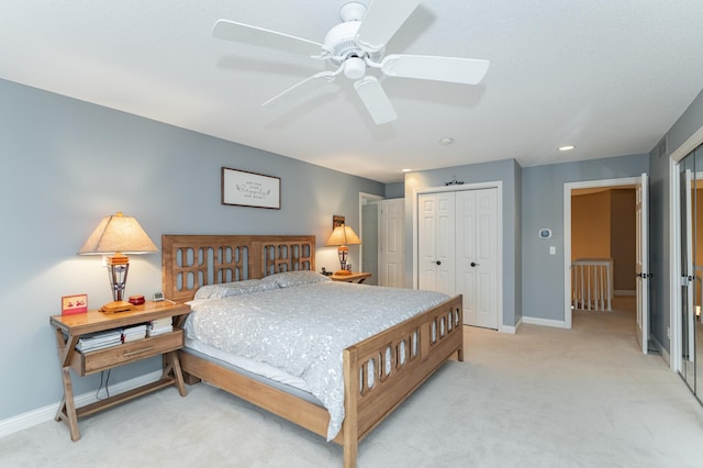 bedroom with a ceiling fan, a closet, light carpet, and baseboards