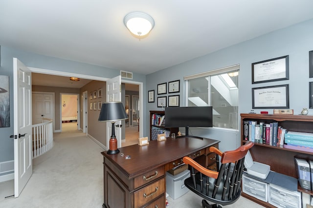 office area with light colored carpet, visible vents, and baseboards