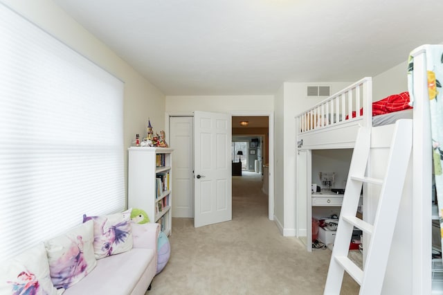 bedroom with visible vents and light carpet