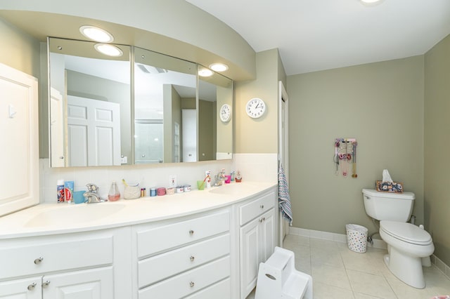 bathroom with backsplash, tile patterned flooring, a sink, and toilet