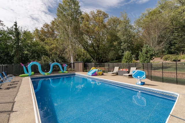 view of swimming pool featuring a patio area, a fenced in pool, fence, and a water slide