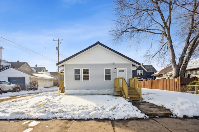 bungalow-style house with a garage and fence