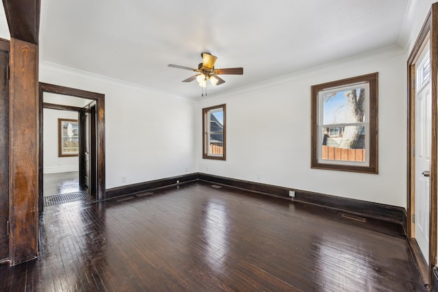 empty room featuring baseboards, dark wood-style flooring, a ceiling fan, and crown molding