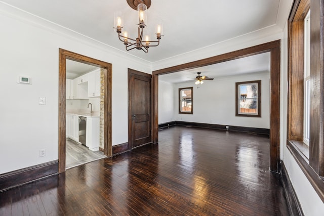 empty room featuring crown molding, hardwood / wood-style floors, ceiling fan with notable chandelier, and baseboards