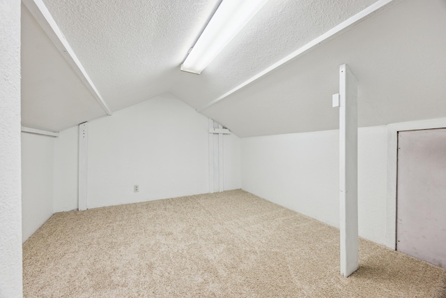 bonus room with a textured ceiling, carpet flooring, and lofted ceiling