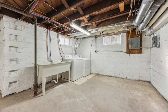 basement featuring electric panel and washing machine and clothes dryer