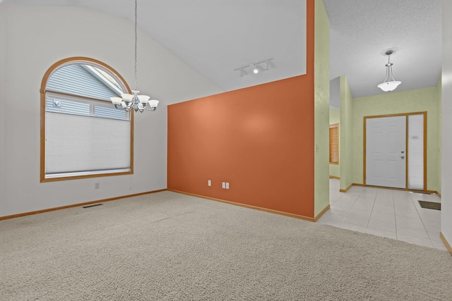 entryway featuring carpet floors, rail lighting, a chandelier, and lofted ceiling