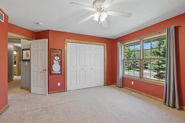 1615 Quasar Ct S, Lake Saint Croix Beach, MN 55043 - unfurnished bedroom with light carpet, baseboards, a textured ceiling, a closet, and a ceiling fan