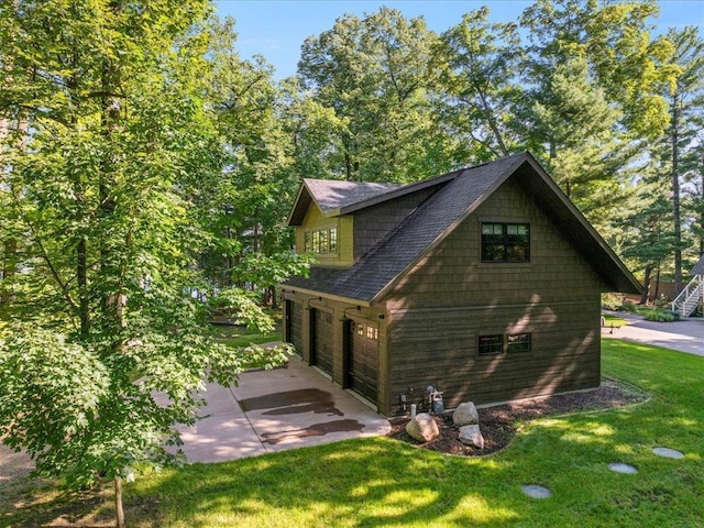 view of side of property featuring a garage and a yard