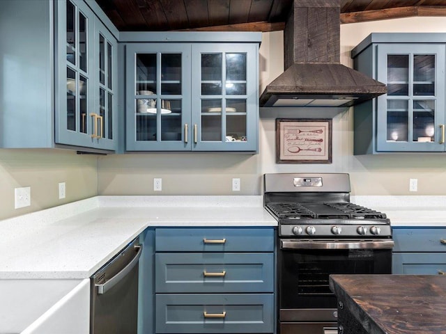 kitchen with blue cabinets, stainless steel appliances, wood ceiling, wall chimney exhaust hood, and glass insert cabinets