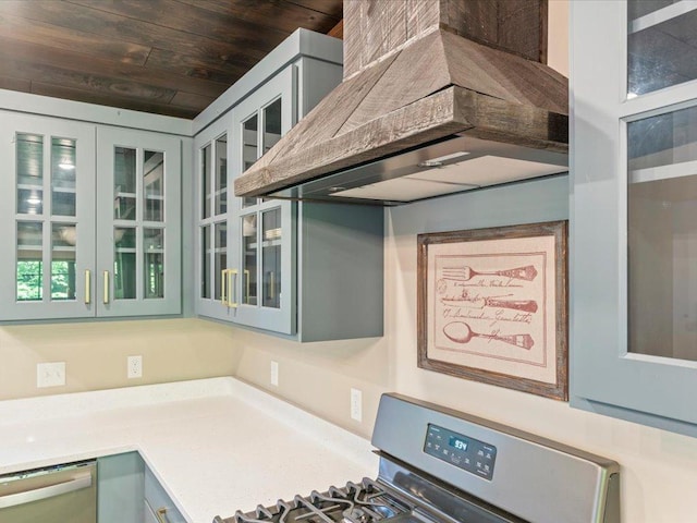 kitchen featuring wood ceiling, light countertops, appliances with stainless steel finishes, glass insert cabinets, and custom range hood