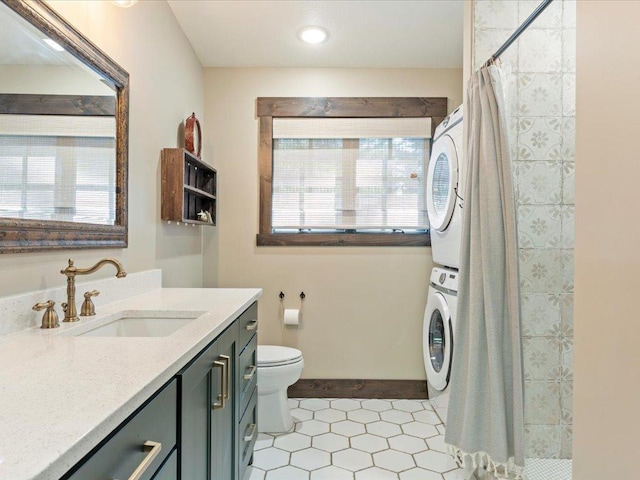 full bathroom with stacked washer / drying machine, a tile shower, vanity, and toilet