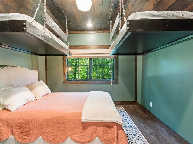 bedroom with wood ceiling, baseboards, and wood finished floors