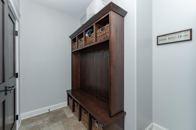 mudroom featuring stone finish flooring and baseboards