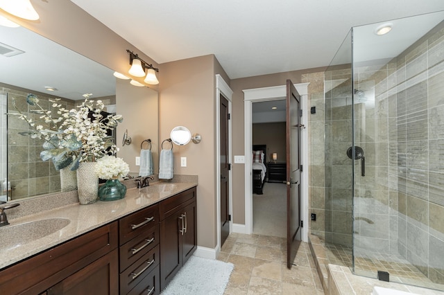 full bathroom with a sink, a stall shower, and double vanity