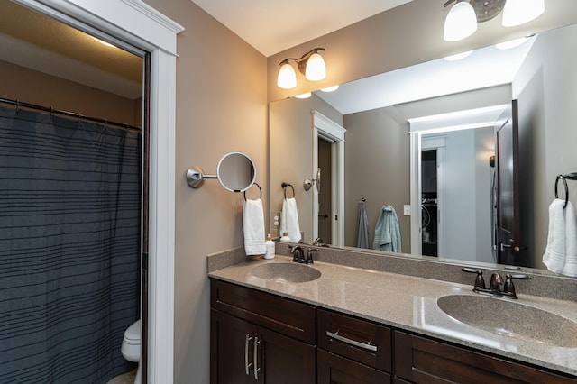 full bathroom with double vanity, toilet, and a sink