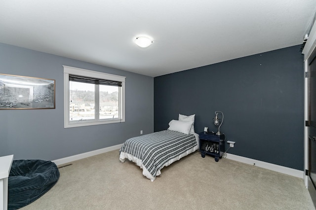 bedroom with baseboards and light carpet