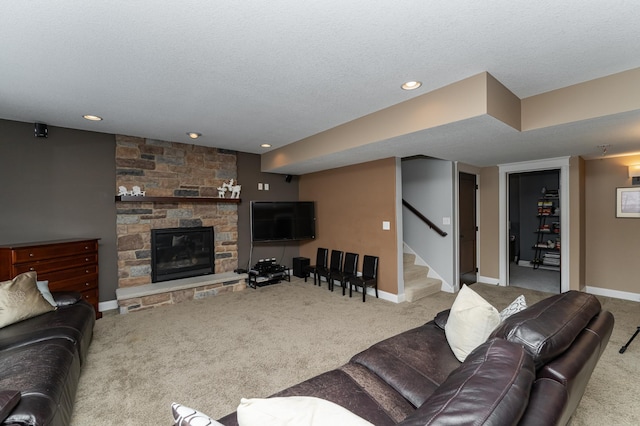 living room featuring baseboards, carpet, a stone fireplace, and stairs