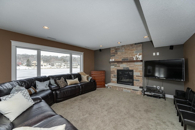 carpeted living area with a stone fireplace and recessed lighting