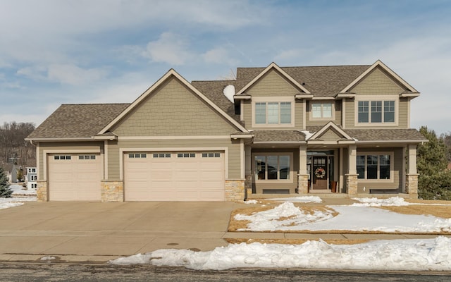 craftsman house with stone siding, driveway, a shingled roof, and a garage