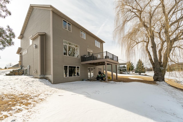 snow covered house with a wooden deck