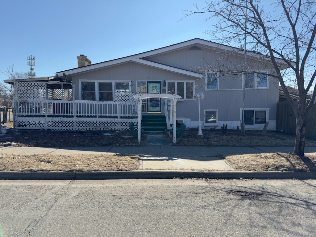 view of front of home featuring a chimney and a wooden deck