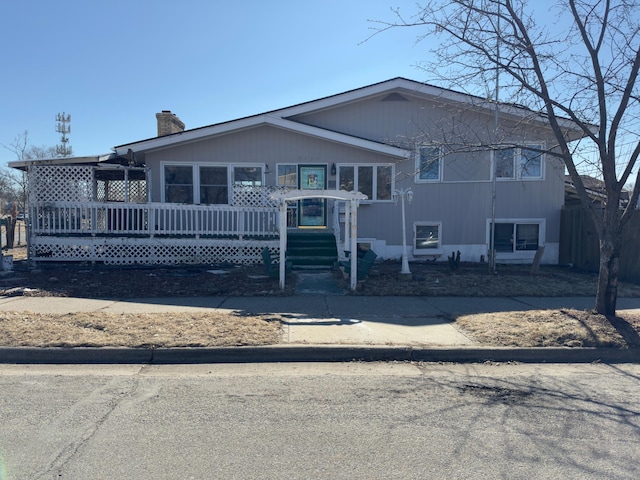 view of front of home featuring a chimney and a wooden deck