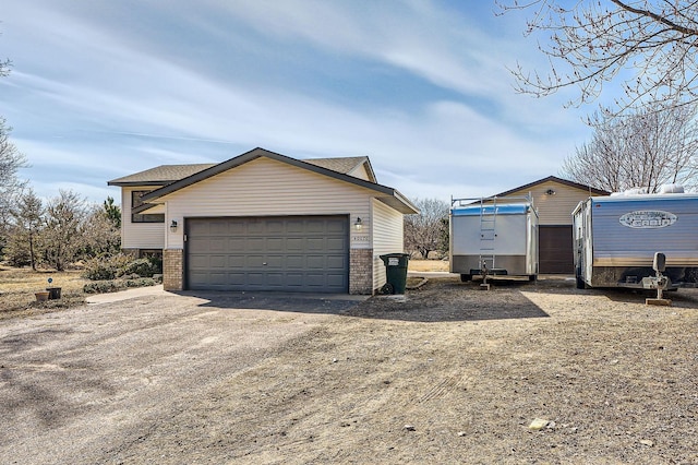 view of home's exterior with an outbuilding, brick siding, and a garage