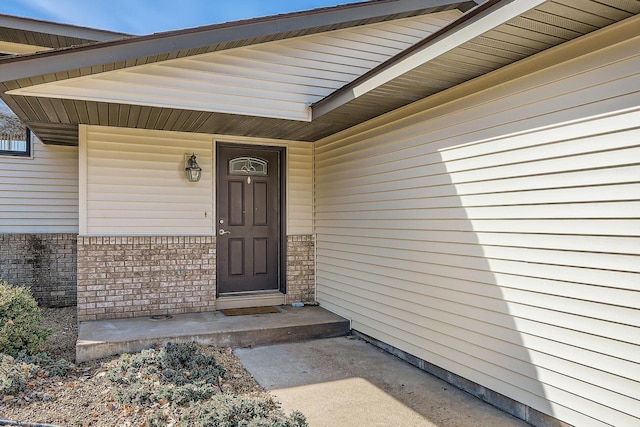 view of exterior entry featuring brick siding