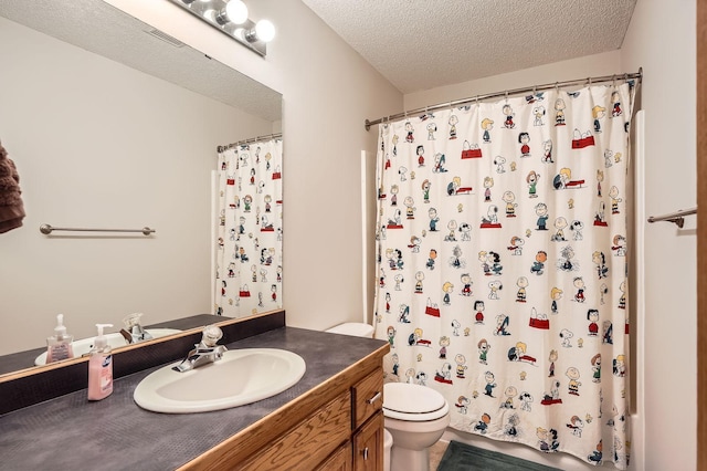 bathroom featuring a textured ceiling, toilet, and vanity