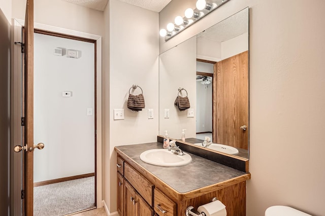 half bathroom featuring toilet, vanity, and baseboards