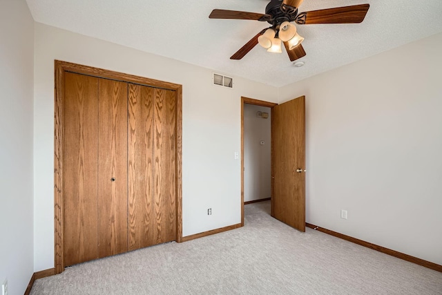 unfurnished bedroom featuring visible vents, baseboards, carpet, a closet, and a textured ceiling