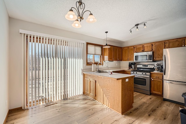 kitchen with light wood-style flooring, stainless steel appliances, a peninsula, brown cabinetry, and lofted ceiling