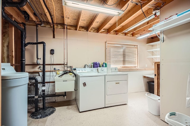 laundry area with laundry area, independent washer and dryer, and a sink