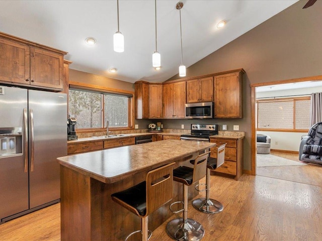 kitchen with light wood-style floors, brown cabinets, appliances with stainless steel finishes, and a sink