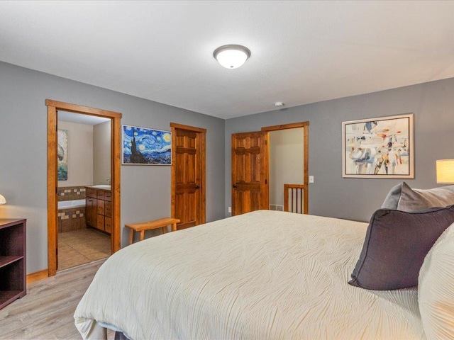 bedroom featuring light wood-type flooring and ensuite bathroom