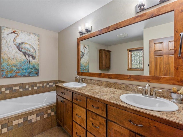 full bathroom featuring double vanity, a bath, visible vents, and a sink